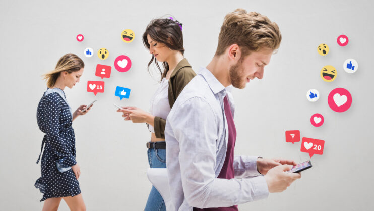 Trzy osoby z telefonami z których wyskakują ikonki związane z social mediami